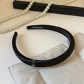 Close-up of elegant black satin headband with diamond accents and handmade label - Black