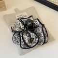 Detalle de pinza para el cabello con estampado floral y bordes rizados en bolsa de lino - Pinza de garra / Floral Crema