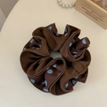Detail view of large dark brown satin scrunchie with blue polka dots and silk folds - Brown