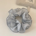 Dettaglio della trama del tessuto a quadretti azzurro e cuciture delicate dello scrunchie - Blu
