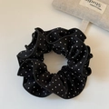 Macro-detail van zwart-witte polkadot scrunchie met zachte geplooide ruches voor het haar - Zwarte Polkadot