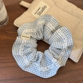 Macro-detail van blauwe ruitjes scrunchie met kant en Hand Made stoffen label - Blauw Geruit