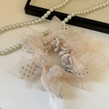 Details des champagnerrosa gepunkteten Organza-Haargummis mit Satin-Schleifen - Beige