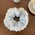 Dettaglio dell'elastico per capelli in pizzo bianco e quadri blu su legno - Blu Pizzo