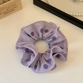 Dettaglio dell'elastico per capelli viola a pois con cucitura a doppio strato rifinita - Viola