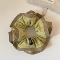 Détail d'un chouchou à double épaisseur en tissu vert clair et textures de lin brun - Jaune