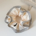 Gros plan d'un chouchou à volants bicolore en satin beige avec bordure en tissu gris chiné - Blanc Cassé