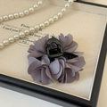 Dettaglio di un fermaglio per capelli a fiore in seta viola su vassoio portagioie - 7cm / Grigio