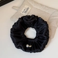 Detail of black pleated satin scrunchie with elegant pearl and vintage metal charm - Black