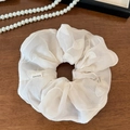 Vue détaillée du chouchou en organza brodé blanc avec une étiquette Hand Made tissée - Broderie Florale