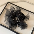 Dettaglio di elastico nero in rete a pois con bordo in organza e perla decorativa - Nero