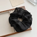 Vue détaillée d'un grand chouchou noir à pois avec tissu multicouche dans une boîte bois - Pois Noir