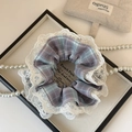 Detailed shot of a blue checkered lace scrunchie on a decorative white display tray - Blue Lace Hair Tie