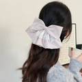 Détail d'un nœud à cheveux à carreaux roses et dentelle blanche sur cheveux longs - Pince à ressort à nœud rose
