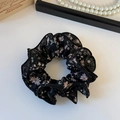 Close-up of elegant black floral double-layer scrunchie with pink flowers on white desk - Black Mesh Floral