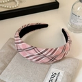 Detail eines rosa karierten Haarreifs mit plissiertem Stoff und Vintage-Ästhetik - Rosa