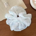 Dettaglio di un elastico in rete bianca con fiori blu su un tavolo di legno rustico - Fiore Blu