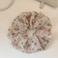 Dettaglio dell'elastico in chiffon beige con stampe floreali arancioni su tavolo bianco - Grande / Beige Stampa Animalier