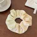 Close-up of yellow plaid and floral fabric scrunchie with a Hand Made label detail - Scrunchie / Yellow Plaid