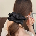 Elegant black oversized mesh scrunchie with silver polka dots on a low bun hairstyle - Solid Color / Black