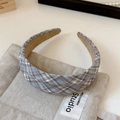 Detailopname van een vintage geruite haarband in blauw en beige met antislip voering - Geribbelde Haarband / Broken Wit