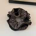 Detail view of coffee mesh floral scrunchie with pleated edges and multi-layered fabric - Brown