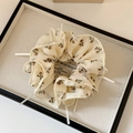 Detalle de coletero floral crema con cintas decorativas en bandeja blanca - Malla Beige Floral
