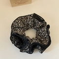 Macro shot of oversized floral scrunchie with delicate black mesh pleated edging and print - Black