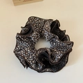 Detailed macro view of vintage dark blue floral scrunchie with elegant black mesh layers - Brown