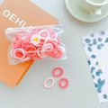 Close-up of colorful elastic hair bands with a daisy charm in a minimalist lifestyle setting - Red Series