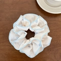 Nahaufnahme von cremefarbenem Spitzen-Scrunchie mit blauem Rand auf Holztisch - Blaues Doppellagiges Haargummi