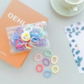 Close-up of pastel macaron color hair ties set in a transparent fashion jewelry pouch - Mixed Color