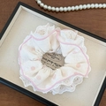 Détail d'un chouchou en dentelle blanche à pois roses avec bords festonnés sur plateau - Chouchou Quatre Couches Rose