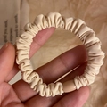 Beige elastic scrunchie with soft pleated fabric and a matching matte buckle detail - Beige