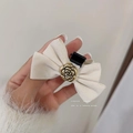 Close-up of beige velvet bow hair clip with a golden camellia flower center detail - Off White