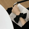 Elegant black satin scrunchie with large bow design worn on wrist for styling - Black Satin
