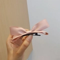 Detail of a soft pink layered satin bow hair clip with a sturdy metal duckbill base - Pink