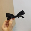 Sweet black satin bow hair clip with metal alligator base shown in a hand-held display - Black