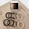 Detailed macro view of earth tone braided and smooth elastic hair ties in a luxury gift box - Braided Style