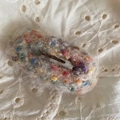 Gros plan d'une pince à cheveux rose au crochet avec des boules de laine colorées - Beige