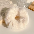 Close-up of a plush beige faux fur scrunchie with soft fluffy texture for autumn hair styling - Plush Style