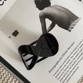 Dettaglio della molletta per capelli nera lucida su sfondo di rivista minimalista - Stile Lucido / Nero-Lucido