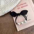 Dettaglio di un elastico per capelli vintage con fiocco nero, perle eleganti e perline d'oro - Nero