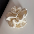 Makroaufnahme von cremeweißem Strick-Scrunchie mit weicher vertikaler Rippenstruktur - Haargummi / Weiß