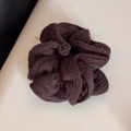 Detailansicht eines kaffeebraunen Strick-Scrunchies mit Rippenmuster und Gummiband - Haargummi / Braun