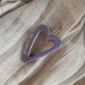 Primer plano de una pinza para el pelo de corazón púrpura mate sobre tela suave - Clip de Presión de Corazón-Púrpura