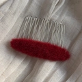 Close-up of fluffy red oval hair comb with silver metal teeth on soft linen fabric - Plush Oval Insert Comb / Red