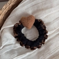 Close-up of leopard print heart scrunchie on textured beige linen with soft lighting - Apricot Heart