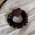 Detailed shot of leopard print scrunchie featuring a brown plush heart on satin fabric - Coffee Heart