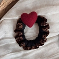Detail of leopard print hair tie featuring a vibrant red 3D heart on textured fabric - Red Heart